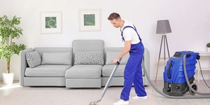 Carpet cleaner using professional vacuum cleaner to remove dirt from carpet. How to start a carpet cleaning business concept.