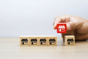 Business person holding a wooden franchise marketing icon.