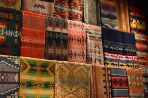 Rows of decorative, ornamental rugs hanging up on display in a room. Professional area rug cleaning concept.