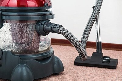 An empty red vacuum cleaner in the middle of the room. Water-Based vacuum concept.