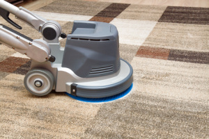 Carpet cleaning with a professional disk machine on the carpet.