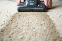 A person operating a rented carpet cleaning machine, demonstrating the ease of use and effectiveness of carpet cleaning equipment rental for home maintenance.